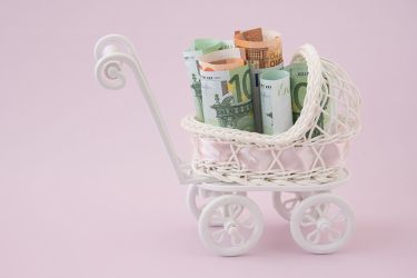 Foto: Miniaturkinderwagen mit Geldscheinen